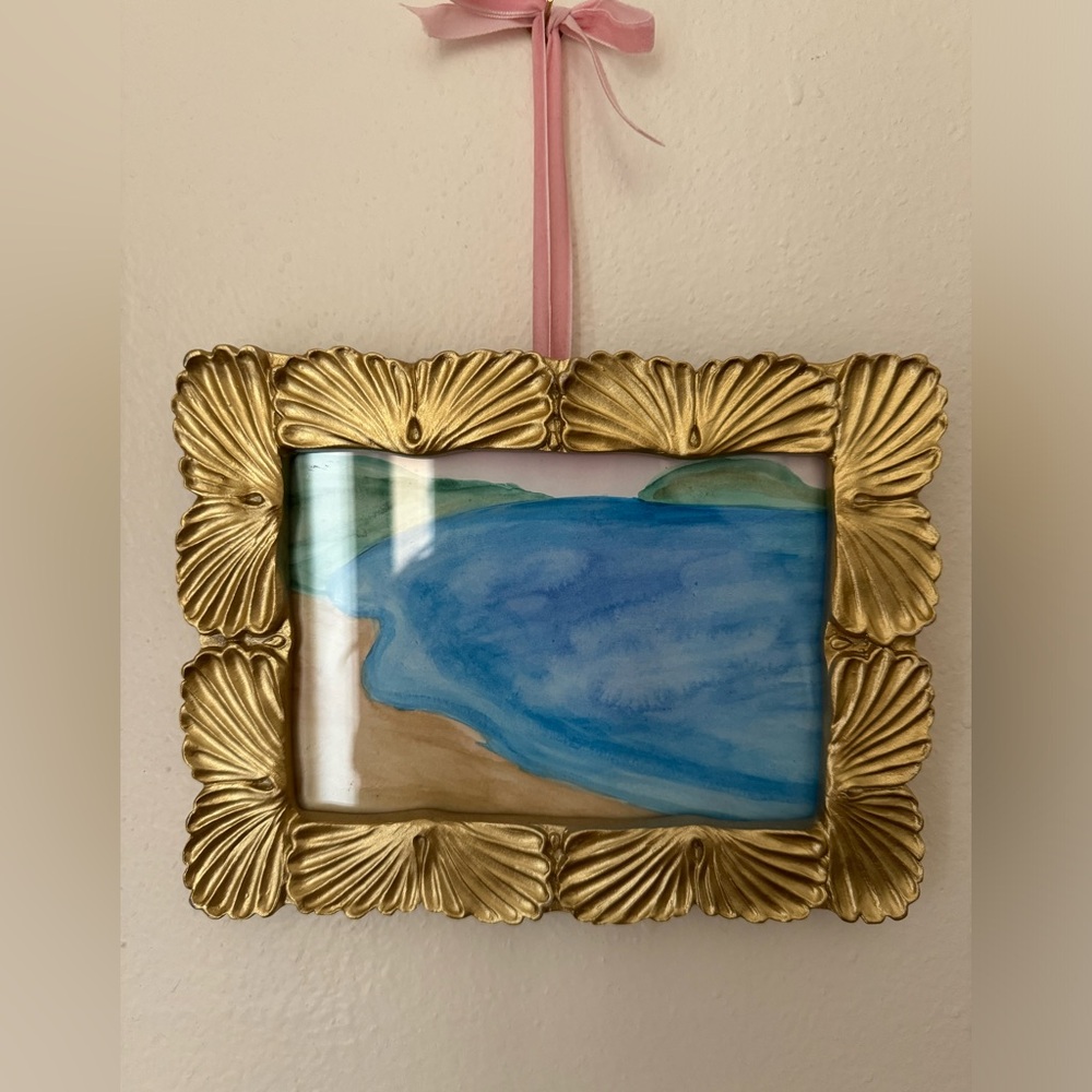 Coastal water color painting with frame and pink bow.